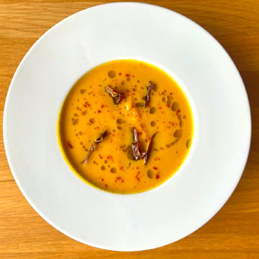 Velouté de courges, chips de lard, huile d’herbes